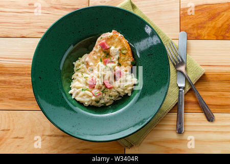 Poulet cordon bleu servi avec risotto d'orzo crème et jambon Banque D'Images