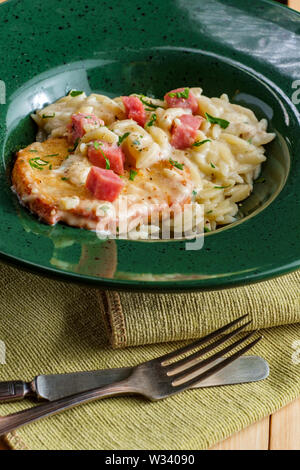 Poulet cordon bleu servi avec risotto d'orzo crème et jambon Banque D'Images