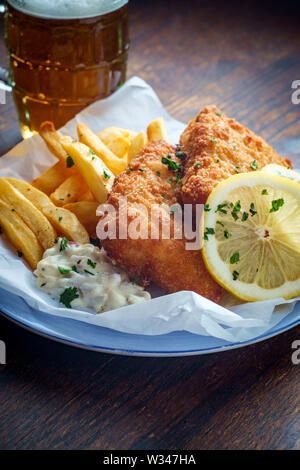 Une cuisine britannique traditionnelle authentique fish and chips servis avec une bière glacée Banque D'Images