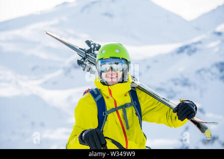 Portrait de l'homme sportif en casque avec skis sur l'épaule Banque D'Images