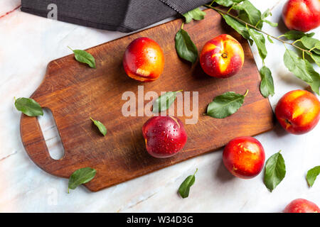 Les nectarines fraîches sur broyeur sur table de marbre Banque D'Images