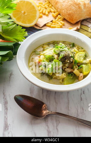 Soupe minestrone végétarienne garni d'oignons verts pesto et parmesan râpé Banque D'Images