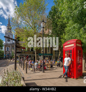 Un homme de soleil dans la rue en scène de rue animée à Clerkenwell Green, Londres, UK Banque D'Images