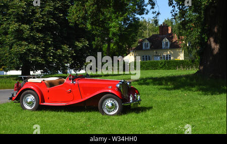 Rouge Classique MG Motor Voiture garée sur Village Green. Banque D'Images