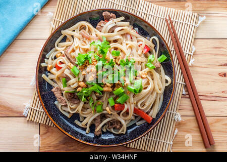 Cuisine authentique pad Thaï au boeuf riz nouilles red bell peppers fèves germées et garnir de chaux Banque D'Images