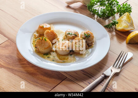 Pétoncles poêlés dans un Portugais blanc vin blanc sauce à l'ail citron Banque D'Images