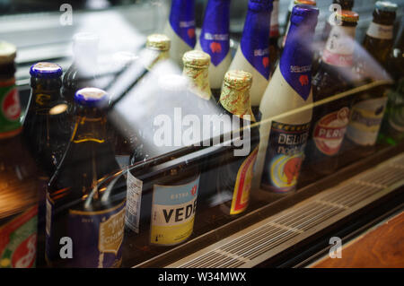 Vedett Extra blanc, Peroni, Brooklyn East IPA, le delirium Nocturnum, Chimay Bleue, les bouteilles de bière Tsingtao le comptoir réfrigéré en Banque D'Images