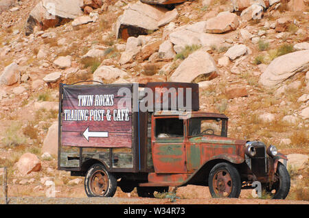 Une ancienne, rouillé out chariot avec un panneau publicitaire de la Twin Rocks Cafe à Bluff, Utah, USA Banque D'Images