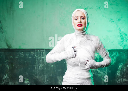 Maman glamour. Portrait d'une jeune femme belle dans des bandages sur tout le corps. Chirurgie plastique ou Halloween concept, feu vert, maman se casse dans Banque D'Images