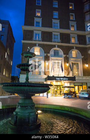 GREENVILLE, SC (USA) - 5 juillet 2019 : une vue sombre de l'hôtel Westin du centre-ville avec une fontaine au premier plan. Banque D'Images