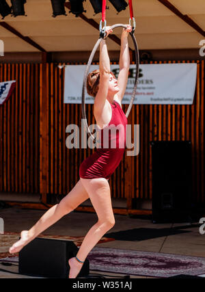 Jeune femme sur la scène aérienne de cirque anneaux cerceaux Lyras Salida ; cirque ; Quatrième de juillet ; performance ; Salida Colorado ; USA Banque D'Images