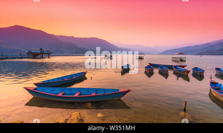 Couleur différents bateaux stationnés dans le Lac Phewa après le coucher du soleil. Pokhara au Népal. Banque D'Images