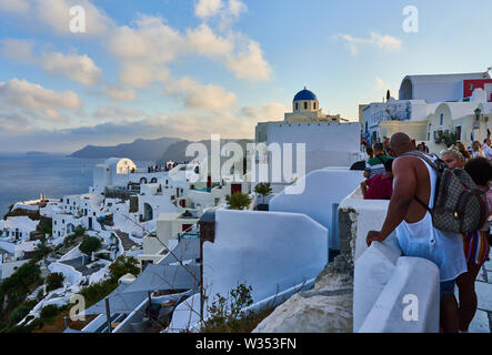 Les touristes dans les restaurants et sur le château d'Oia attendre le coucher du soleil avec vue sur la caldeira et le célèbre Moulin à Oia, Santorin, Grèce au 04 juin 2019. © Banque D'Images