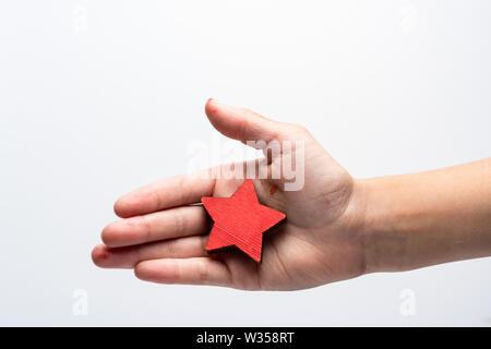 Étoiles dans la main de l'enfant. Signe d'approbation rouge sur un fond blanc. Banque D'Images