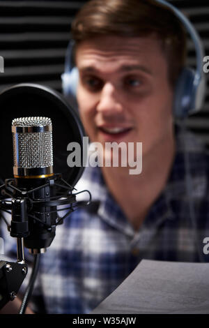 Dans l'homme parle dans le microphone de studio d'enregistrement Banque D'Images