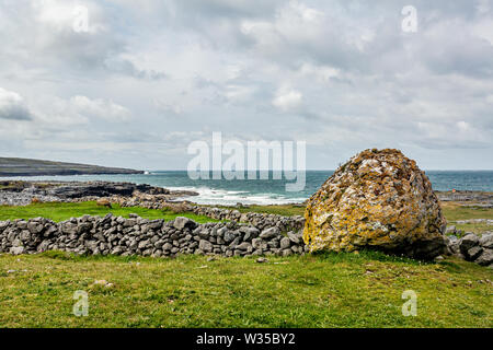 Paysage irlandais d'un géant de pierre en pierre à côté d'une clôture avec la mer en arrière-plan entre Bothar nA hAillite et Fanore, façon sauvage de l'Atlantique Banque D'Images