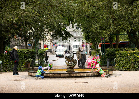 Enfants jouant dans la fontaine par Lille Lungegårdsvannet Fiskeren (Smålungeren) et Christies gate dans le centre de Bergen, Norvège. Banque D'Images