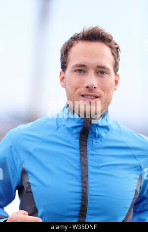 Homme qui court en plein air libre à l'automne dans runner outfit veste. Jogging athlète masculin à l'extérieur à l'automne sur la formation journée froide. Concept de vie sain. Banque D'Images