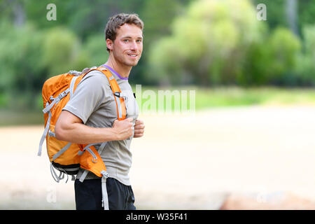 Portrait de l'homme sac à dos de randonnée avec des balades dans la nature. Caucasian man smiling happy avec forêt en arrière-plan lors de voyage d'été dans la région de Yosemite National Park, California, USA. Banque D'Images