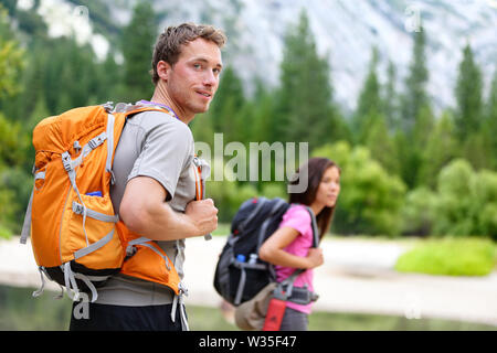 Les randonneurs - people hiking, man mountain nature paysage scenic avec femme en arrière-plan. Happy young couple multiculturel dans Yosemite National Park, California, USA Banque D'Images