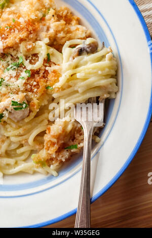 Du Poulet Alfredo crémeux avec pâtes spaghetti parmesan garni de mozzarella et de fromages et de chapelure panko Banque D'Images