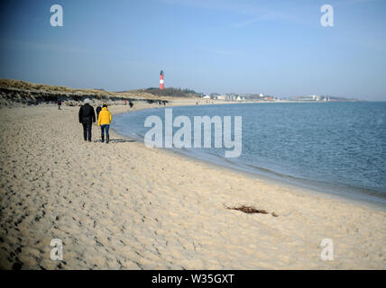 Sylt, Allemagne. Feb 18, 2019. Walker sur la plage vers le phare Hörnum sur l'île de Sylt. Sylt est la plus grande île du Nord en Allemagne. Credit : Britta Pedersen/dpa-Zentralbild/ZB/dpa/Alamy Live News Banque D'Images