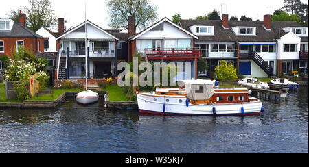 Propriétés au bord de l'eau et vieux jeu cruiser sur la rivière Bure à Horning. Banque D'Images