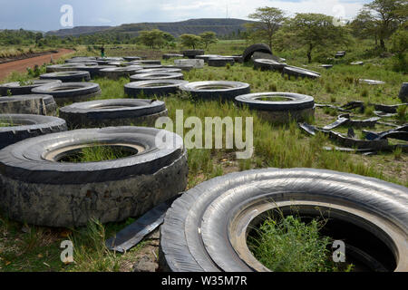 La TANZANIE, Distrikt Tarime, Nyamongo, la filiale canadienne Barrick Gold Mine d'Acacia, les vieux pneus de dumper, derrière des morts-terrains / TANZANIE, Abraumhalden der Acacia Gold Mine, verschlissene Reifen der grossen Dumper auf einer Muellhalde Banque D'Images