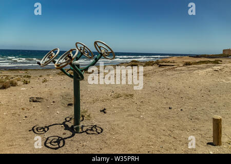 Terrain de sport le long de la côte avec différents équipements de gymnastique. Chaude journée ensoleillée et douce surf. De vie sport concept. El Medano, Tenerife, Banque D'Images