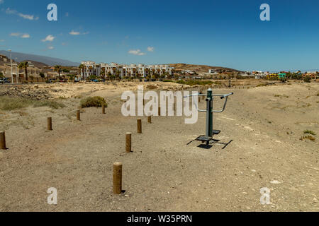 Terrain de sport le long de la côte avec différents équipements de gymnastique. Chaude journée ensoleillée et douce surf. De vie sport concept. El Medano, Tenerife, Banque D'Images