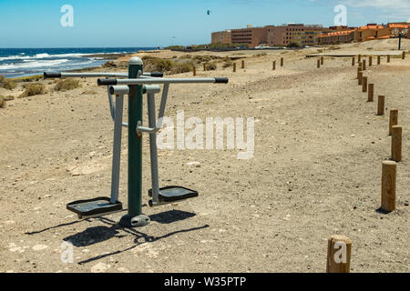 Terrain de sport le long de la côte avec différents équipements de gymnastique. Chaude journée ensoleillée et douce surf. De vie sport concept. El Medano, Tenerife, Banque D'Images