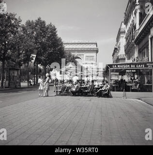 Années 1960, historique, diurne et personnes assises devant la Maison du Café, un café-restaurant situé sur un trottoir à l'extrémité supérieure des champs-Elysées, à proximité du célèbre monument parisien, l'Arc de Triomphe. Banque D'Images