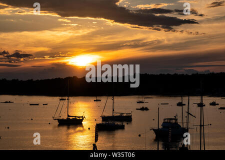 Voiliers amarrés au coucher du soleil un soir d'été à Boothbay Harbor Maine. Banque D'Images