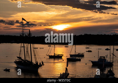 Voiliers amarrés au coucher du soleil un soir d'été à Boothbay Harbor Maine. Banque D'Images