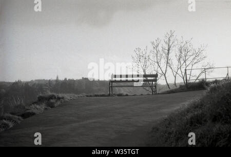 années 1950, historique, un banc en bois sur un chemin à flanc de colline surplombant le paysage environnant. Banque D'Images