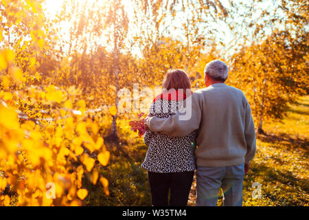 Couple en forêt d'automne. Middle-aged man and woman hugging et de refroidissement à l'extérieur. Les gens parler et profiter de la nature Banque D'Images