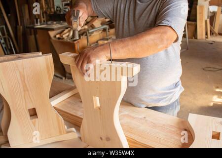 Menuisier travaillant. Mains doing woodwork avec lumière naturelle. Outils de travail du bois. Banque D'Images