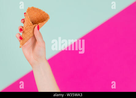 Close up female hand holding empty for ice cream cone wafer Banque D'Images