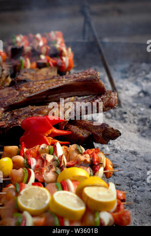 Un barbecue argentin typique. Un grand morceau de viande et de légumes brochettes sur le grill. Banque D'Images