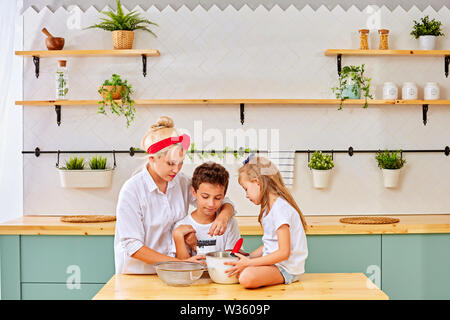 Famille heureuse dans la cuisine. la mère et l'enfant la préparation de la pâte, faire cuire des biscuits Banque D'Images