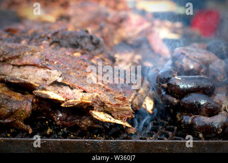 Argentin traditionnel "asado" (barbecue). Les gros morceaux de viande et les boudins sur le grill. Banque D'Images