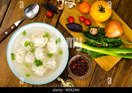 Bouillon chaud avec raviolis et les oignons verts. Studio Photo Banque D'Images