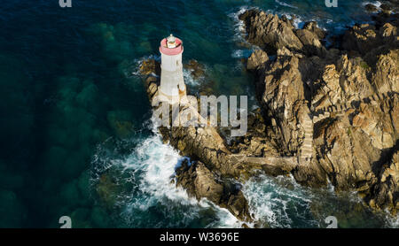 Vue de dessus, superbe vue aérienne d'une vieille et belle plage situé sur une côte rocheuse baignée par une mer agitée. Faro di Capo Ferro. Banque D'Images