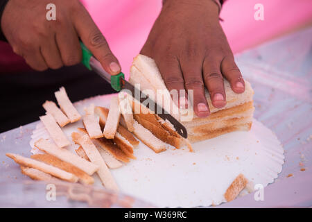 Homme coupe manuelle du pain frais sur la table du pain de près. Du pain frais sur la table de cuisine La saine alimentation et boulangerie traditionnelle concept - Image Banque D'Images