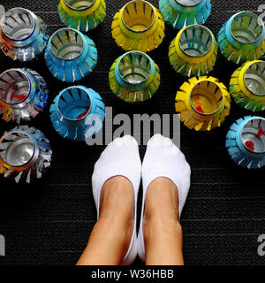 Femme pieds de chaussettes blanches et de groupe de lanternes bijou de recyclage des canettes de bière, une activité d'accueil à temps libre dans la journée d'été Banque D'Images