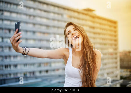 Jeune femme prenant en selfies scène urbaine ville Banque D'Images