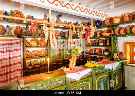 Céramique peint de bols, assiettes et de bidons sur une planche en bois sur le mur, un vieux comptoir avec verrerie dans l'intérieur d'un vieux café et rurales de l'Ukraine Banque D'Images