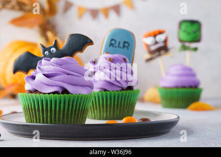 Halloween fête treats - cupcakes colorés, gingerbread cookies et guimauve sucrée des monstres. Focus sélectif. Banque D'Images