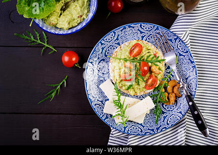 Toasts avocat sain pour le petit déjeuner ou le déjeuner, d'avocat, roquette, tomates, noix de cajou, fromage feta et le poivre. Des sandwiches végétariens. Vue d'en haut Banque D'Images