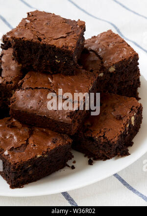 Des petits brownies au chocolat sur une assiette blanche, vue de côté. Libre. Banque D'Images